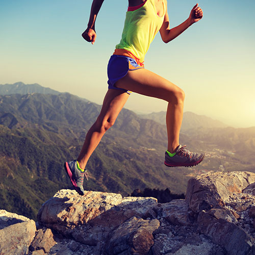 Knee Replacement Surgery - Woman Leaping Between Rocks in Mountain Range Area